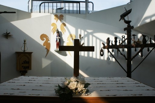 Dans la chapelle de la péniche, l'autel. A droite, la reproduction d'une croix de marinier.