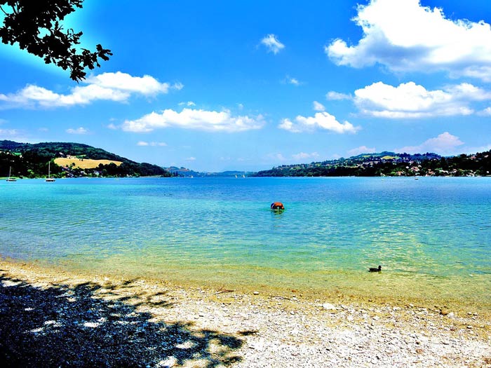 L'une des plages du lac de Paladru entouré de son eau turquoise pour se baigner. CC