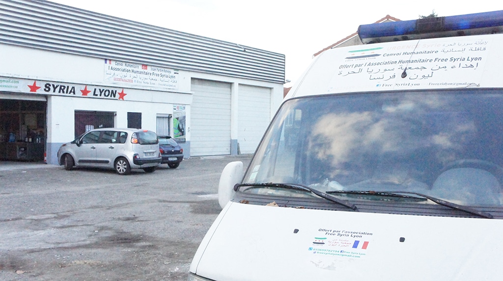 Une ambulance qui devra être réparée avant de partir pour la Syrie. A l'arrière-plan, l'entrepôt de l'association. ©Rue89Lyon