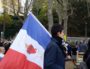 Le rassemblement des cathos tradis pour "sauver" l'église Saint-Bernard. Des drapeaux français ornés du "cœur sacré de Jésus" ont été distribués aux participants. ©LB/Rue89Lyon