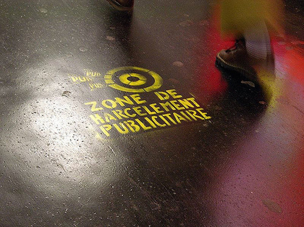 "Zone de harcèlement publicitaire" Sur le sol luisant du métro. Paris, mai 2005. Photo CC BY-NC-SA 2.0 by Palagret via Flickr