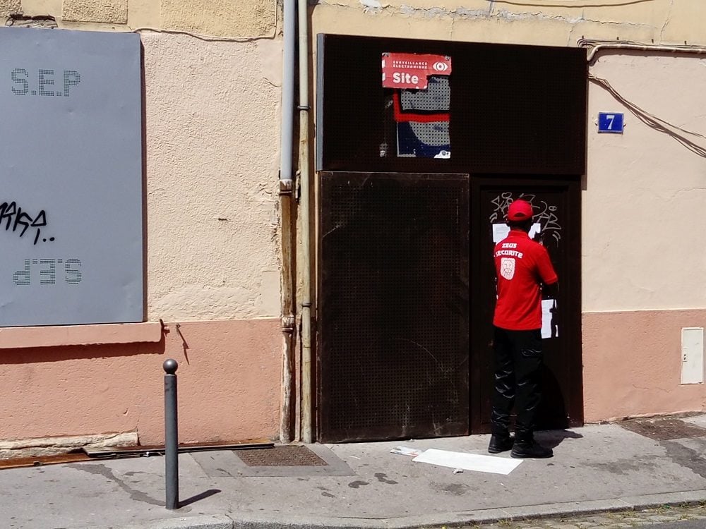 Après l'intervention de la police, l'entrée du squat est gardée par un agent de sécurité.