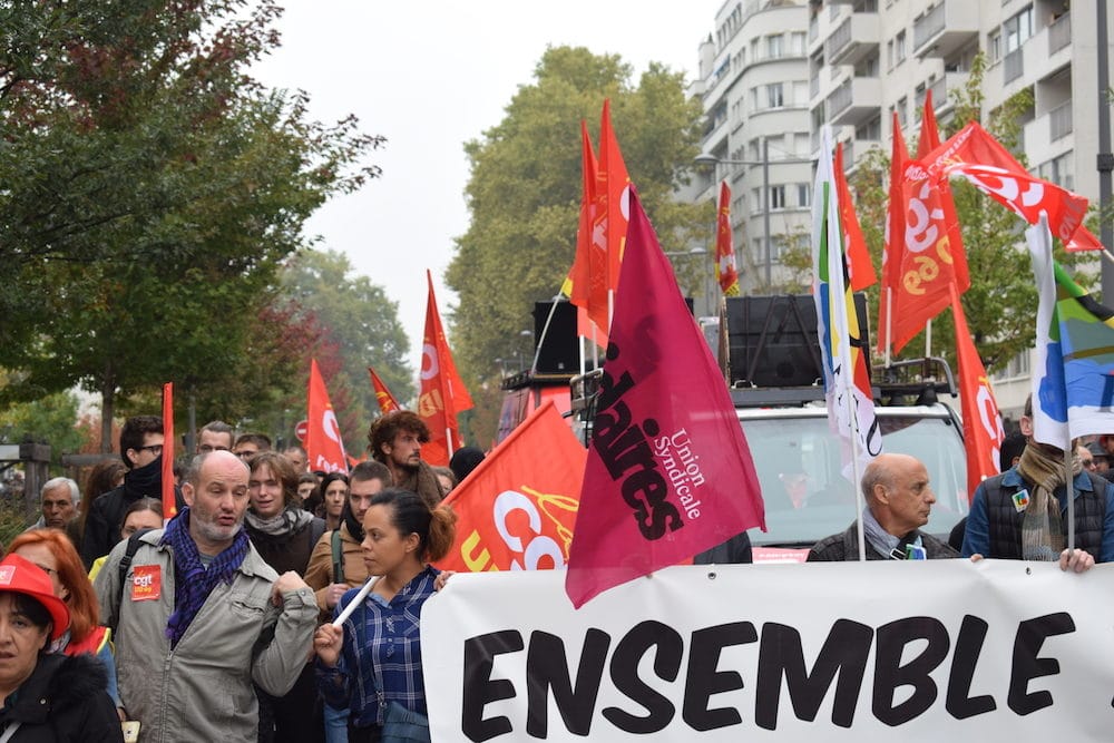 Des représentants des différents syndicats tiennent la banderole de tête. @ Aurélien Defer