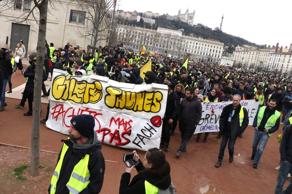 Acte XIII, samedi 9 février 2019, départ de la manifestation des "gilets jaunes" place Bellecour à Lyon. Une banderole est déployée par les antifa pour protester contre les groupuscules d'extrêmes droite. ©MG/Rue89Lyon