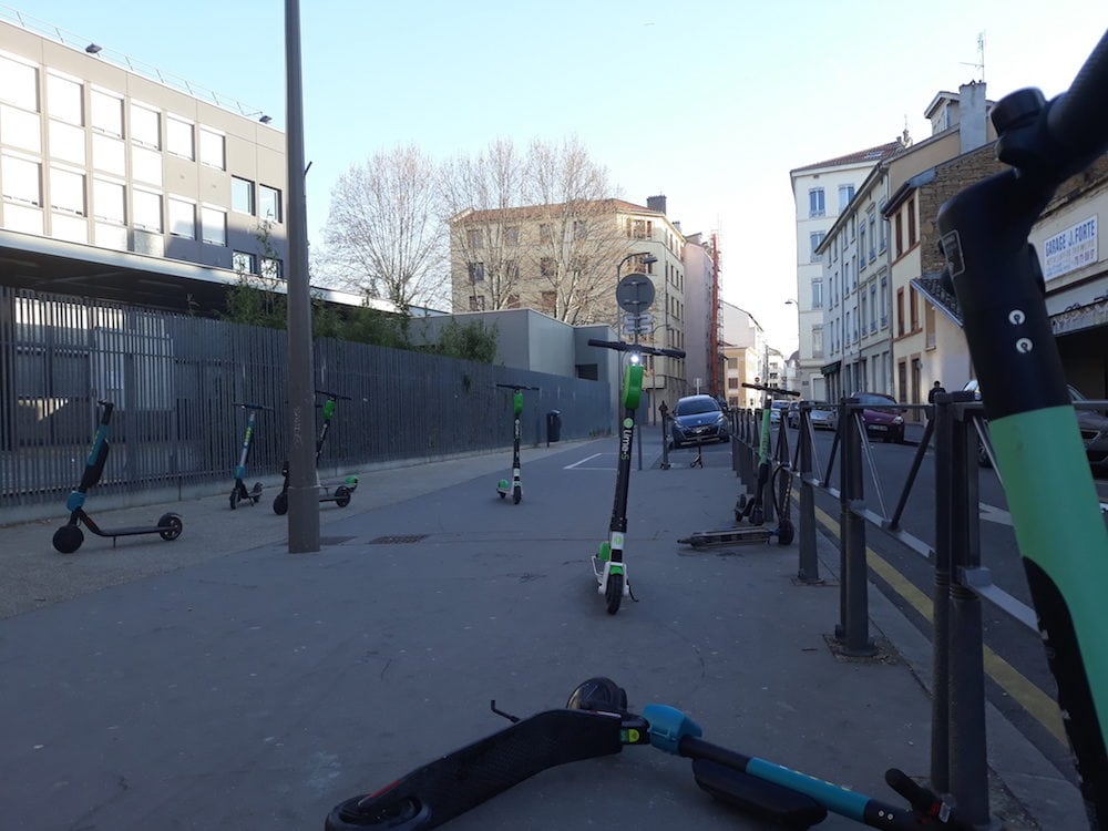 Onze trottinettes stationnées le 22 mars à 8 heures sur le trottoir devant l'entrée du collège Clémenceau. ©LB/Rue89Lyon