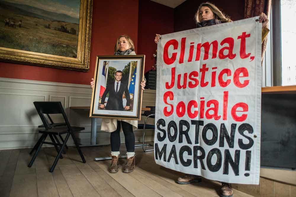 Fanny Delahalle tenant le portrait d'Emmanuel Macron dans la mairie du 2e arrondissement au moment de l'action, le 21 février dernier. ©Simon-Cavalier