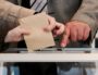 Électeur s'apprêtant à mettre son bulletin de vote dans l'urne. Photo CC par Arnaud Haegers