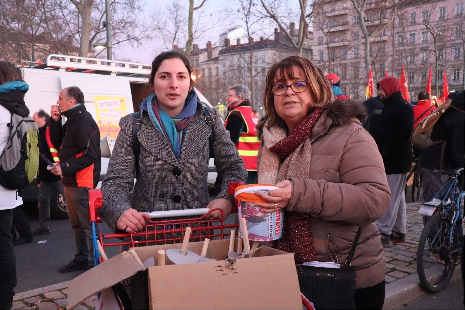 Deux femmes vendent des torches pour la manifestation aux flambeaux