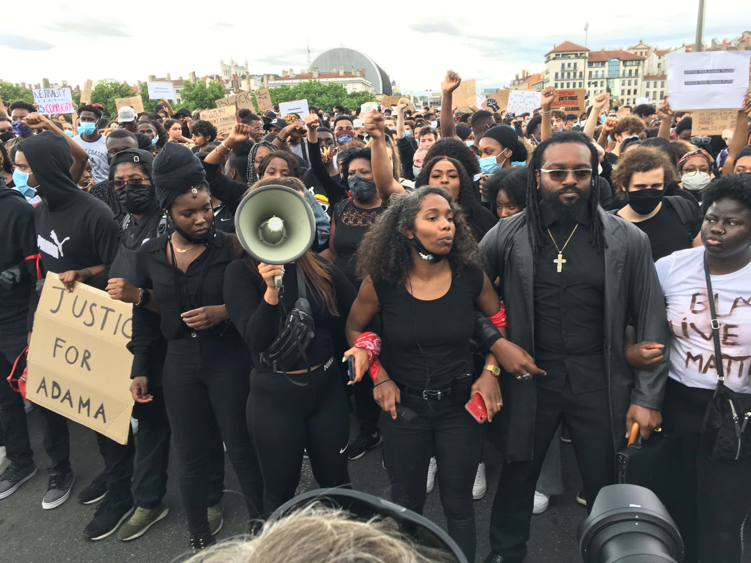 Sur la fin du parcours, les organisateurs (la présidente d'Afro-Descendants à gauche, et Sonia avec le mégaphone à sa droite) ont demandé aux manifestants de se tenir par les coudes, pour former une chaîne humaine, symbole de solidarité et de fraternité. ©AB/Rue89Lyon