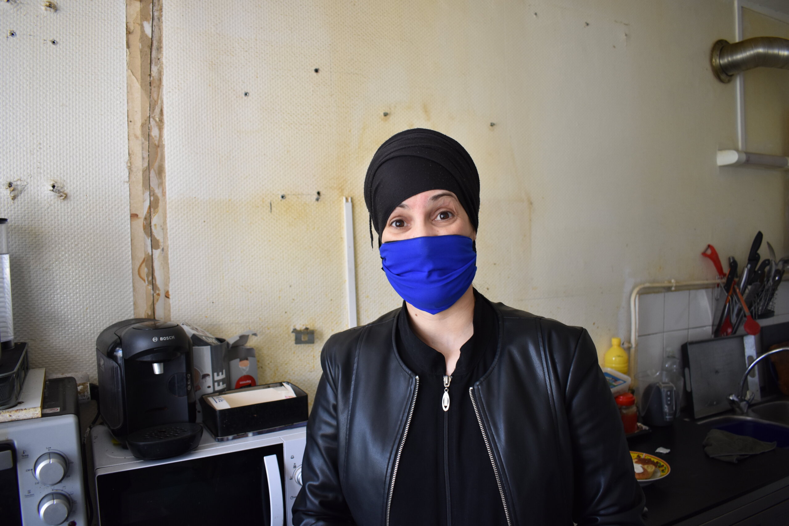 Zohra, dans sa cuisine au murs abîmés par l'humidité ©LS/Rue89Lyon