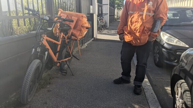 Un des livreurs de Just Eat, à Lyon, à côté de son vélo électrique ©LSRue89Lyon