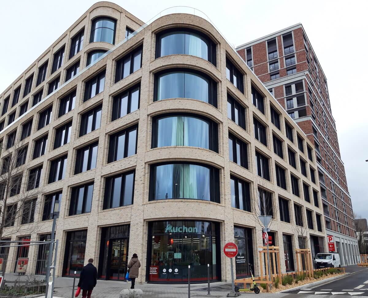 L'immeuble de bureaux le Brickwall avec au rez-de-chaussée le supermarché Auchan et, derrière, le Vill’Arboréa Plaza à Gerland ©LB/Rue89Lyon