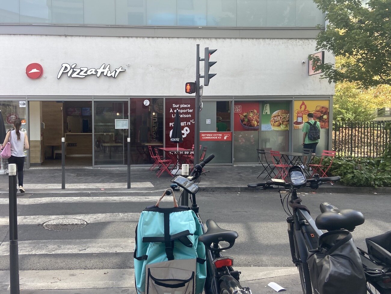 Dans le 8ème arrondissement de Lyon, Rue Audibert et Lavirotte, la dark kitchen Out Fry est installée juste derrière les tables du Pizza Hut. Les livreurs attendent en face les commandes. ©Marine Delrue/Rue89Lyon 2022.