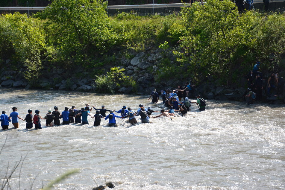 Les manifestants traversent la rivière de l'arc