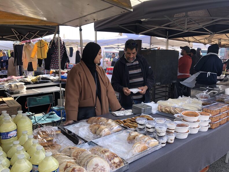 Certains exposants, ne sont pas des professionnels mais des habitants qui vendent des plats cuisinés en famille, comme Hajer Mhraihi et son père. ©MA/Rue89Lyon