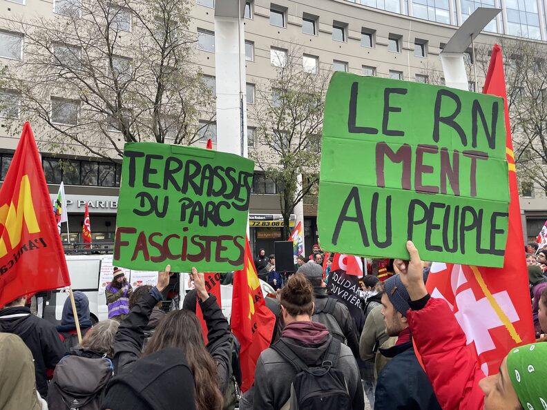 Des pancartes dénonçant le RN et les Terrasses du parc au rassemblement anti-RN à Villeurbanne. ©MA/Rue89Lyon
